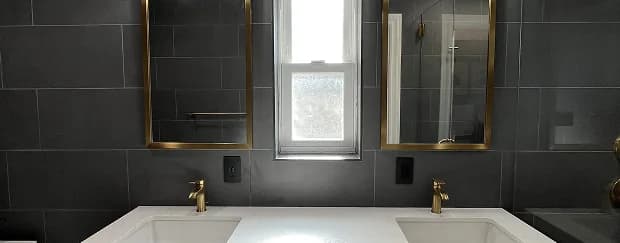 Finished ADU bathroom with dark tile and brass fixtures by ADU San Mateo